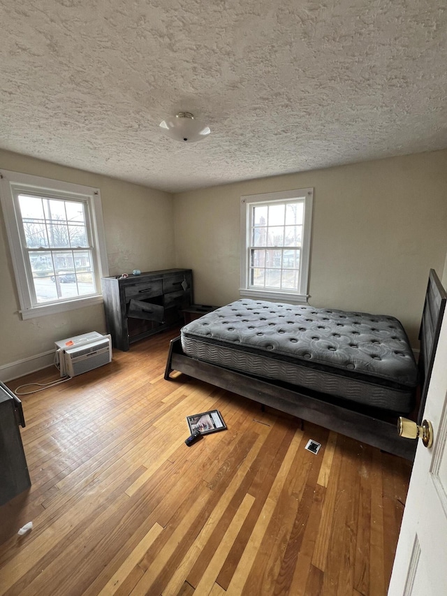 bedroom featuring a textured ceiling and light hardwood / wood-style floors