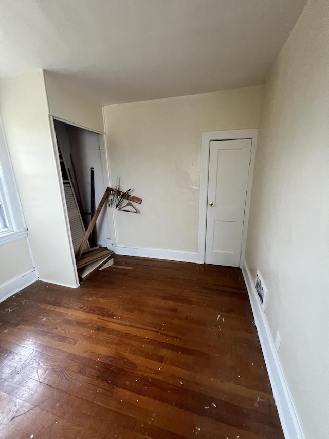 unfurnished room with dark hardwood / wood-style flooring