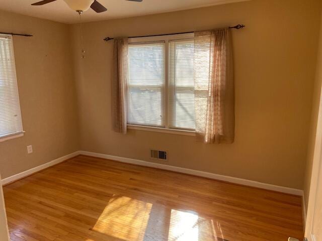 spare room with ceiling fan, light hardwood / wood-style floors, and a healthy amount of sunlight