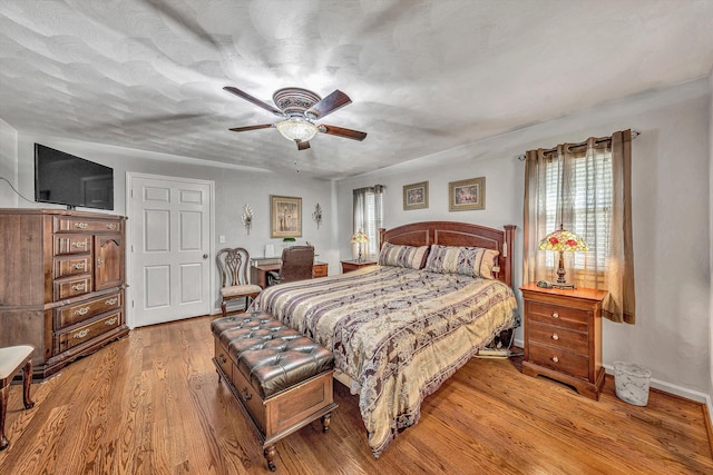 bedroom featuring ceiling fan, a textured ceiling, and light wood-type flooring