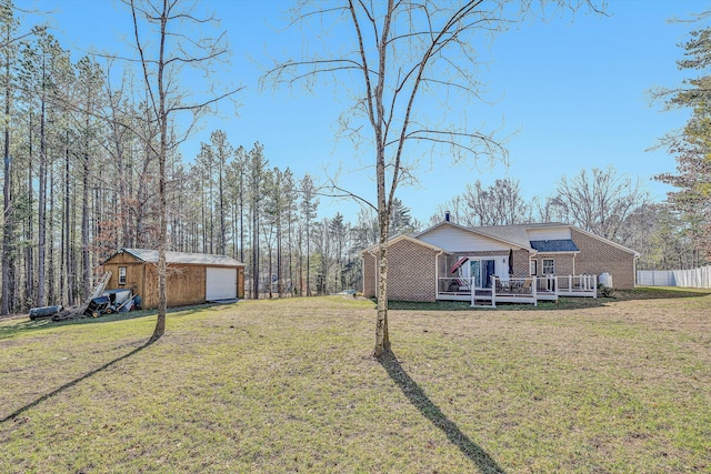 view of yard with an outbuilding, a garage, and a deck