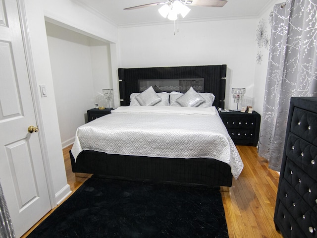 bedroom featuring crown molding, wood-type flooring, and ceiling fan