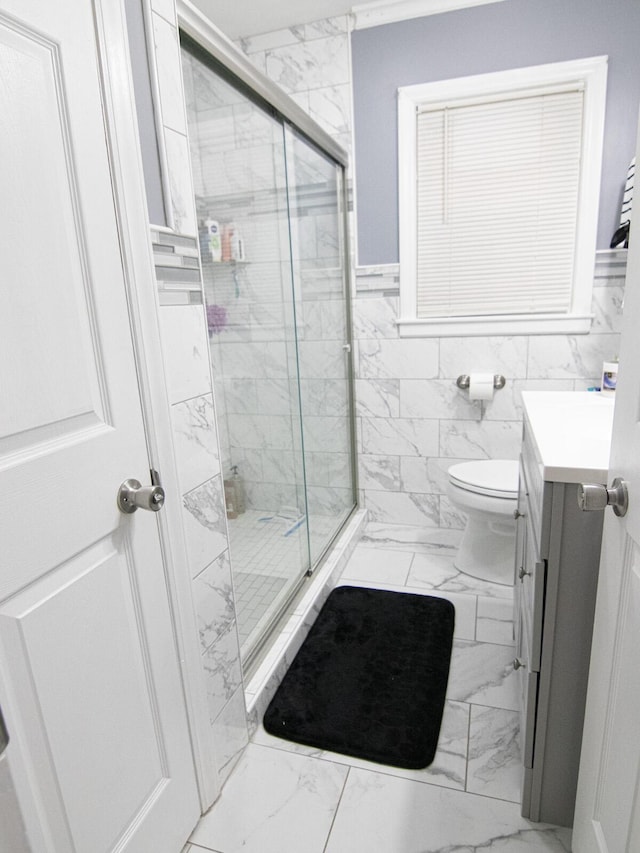 bathroom with vanity, an enclosed shower, tile walls, and toilet