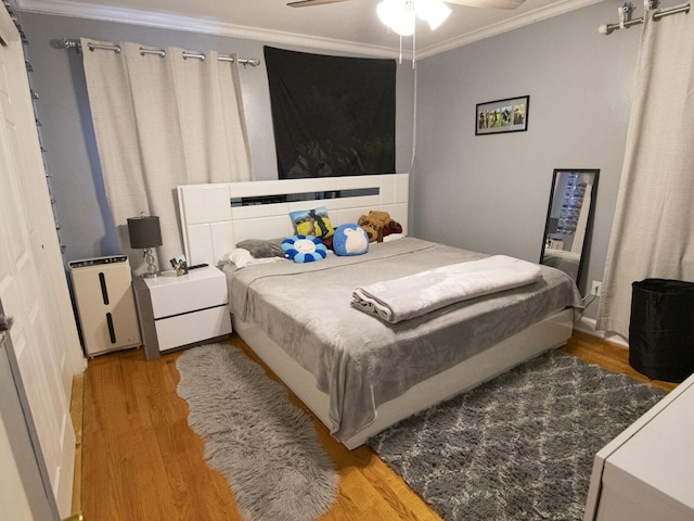 bedroom featuring ornamental molding, ceiling fan, and light wood-type flooring