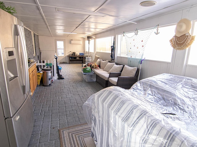 bedroom with stainless steel fridge with ice dispenser and a wall mounted AC