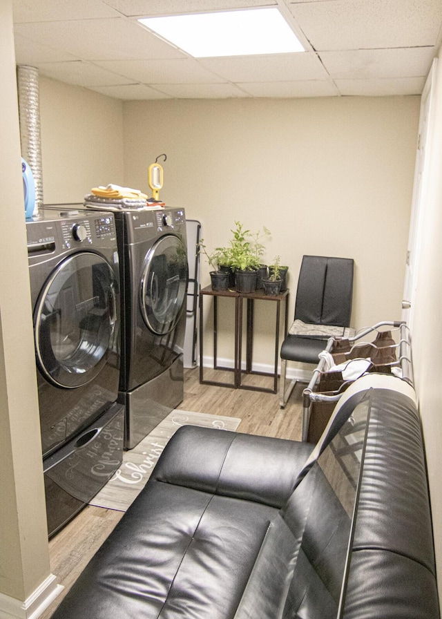 laundry area featuring washing machine and clothes dryer and light wood-type flooring