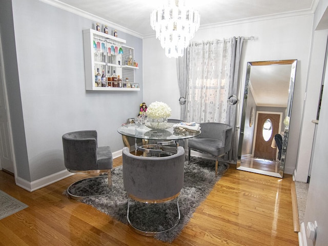 dining room featuring crown molding, hardwood / wood-style flooring, and an inviting chandelier