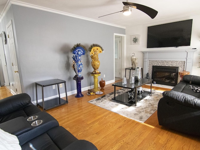 living room featuring hardwood / wood-style flooring, ornamental molding, and ceiling fan