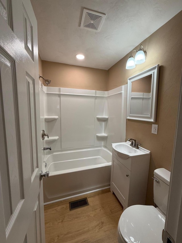 full bathroom featuring vanity, wood-type flooring, toilet, and shower / bath combination