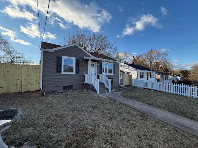 bungalow-style home with a front yard and fence private yard