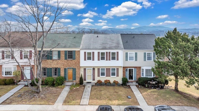 view of front of property with a mountain view and a front lawn