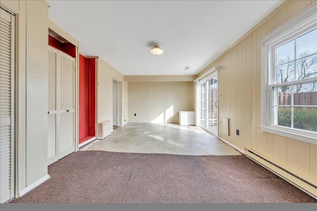 interior space featuring concrete flooring, ornamental molding, and baseboard heating