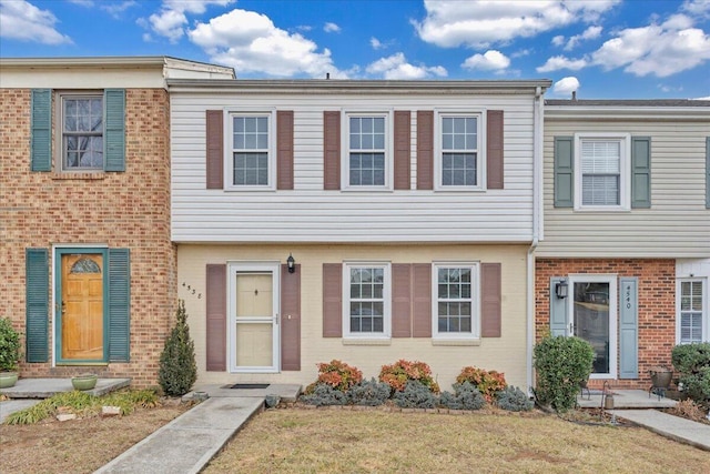 townhome / multi-family property featuring a front lawn