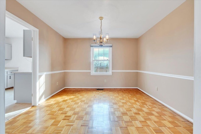 unfurnished room with a chandelier and light parquet floors