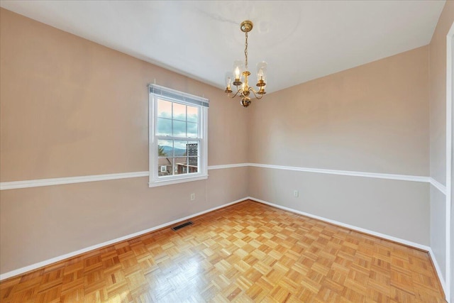 unfurnished room featuring parquet floors and a notable chandelier