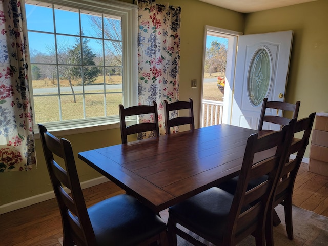 dining space with baseboards and wood finished floors