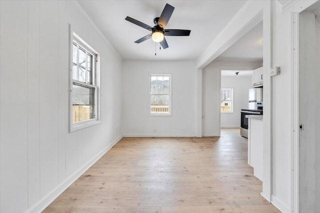 spare room with light wood-style flooring, baseboards, and a ceiling fan