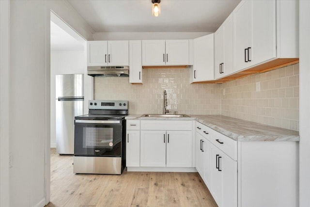 kitchen with white cabinets, light wood-style floors, stainless steel appliances, under cabinet range hood, and a sink