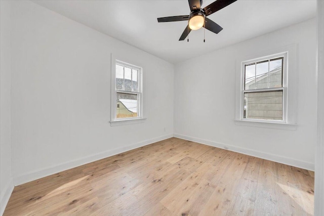 unfurnished room with a ceiling fan, light wood finished floors, and baseboards