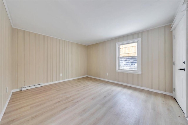 unfurnished room with a baseboard radiator and light wood-style flooring