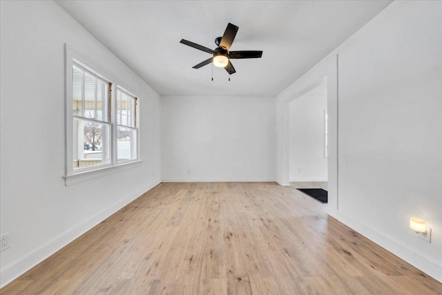 empty room with light wood-type flooring, ceiling fan, and baseboards