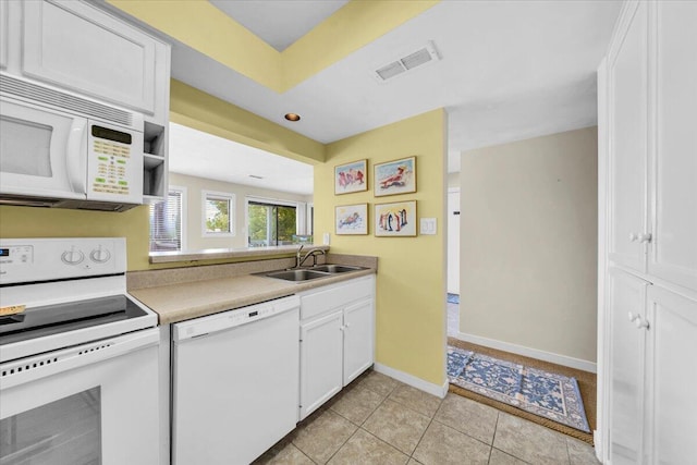 kitchen featuring white cabinetry, sink, light tile patterned floors, and white appliances