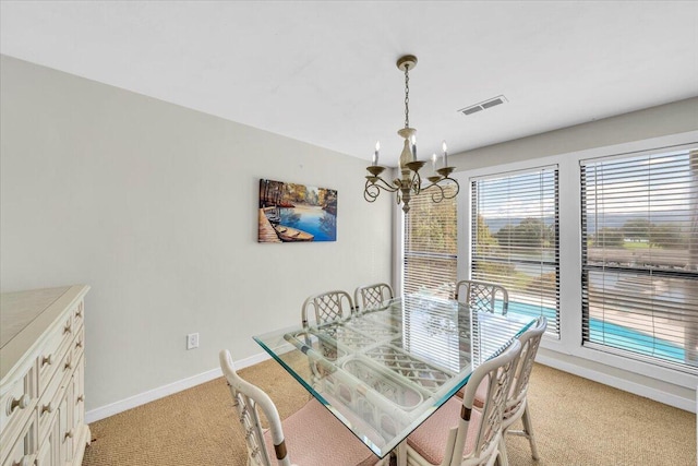 carpeted dining area with a notable chandelier