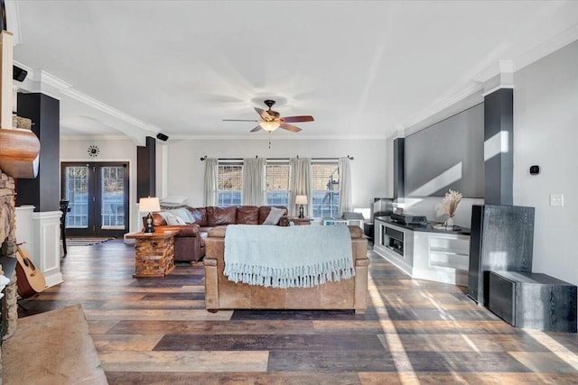 living room featuring dark wood-type flooring, ornamental molding, french doors, and a wealth of natural light