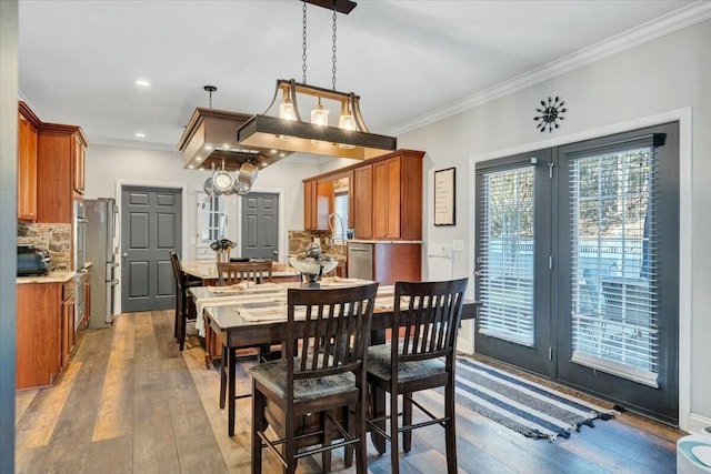 dining area featuring light hardwood / wood-style flooring and ornamental molding