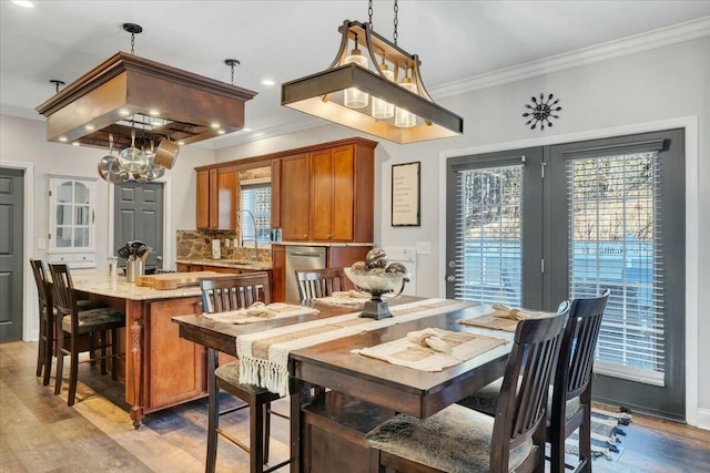 dining room featuring ornamental molding, light hardwood / wood-style floors, and sink