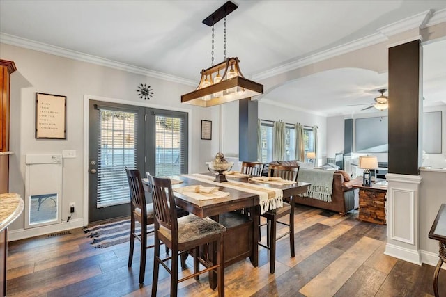 dining area with dark wood-type flooring, ornamental molding, and ceiling fan