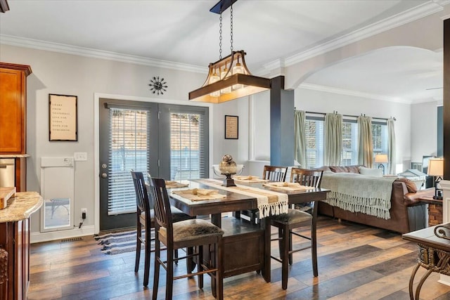 dining area with ornamental molding and dark hardwood / wood-style floors