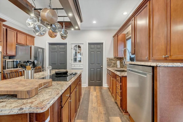 kitchen featuring light stone counters, dishwasher, sink, and a breakfast bar area