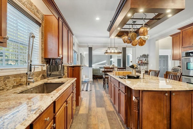 kitchen with pendant lighting, light stone counters, a kitchen breakfast bar, and a kitchen island