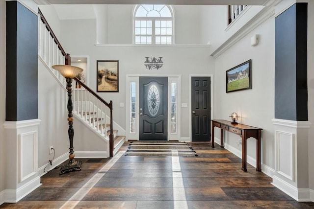 entryway featuring a towering ceiling and dark hardwood / wood-style flooring