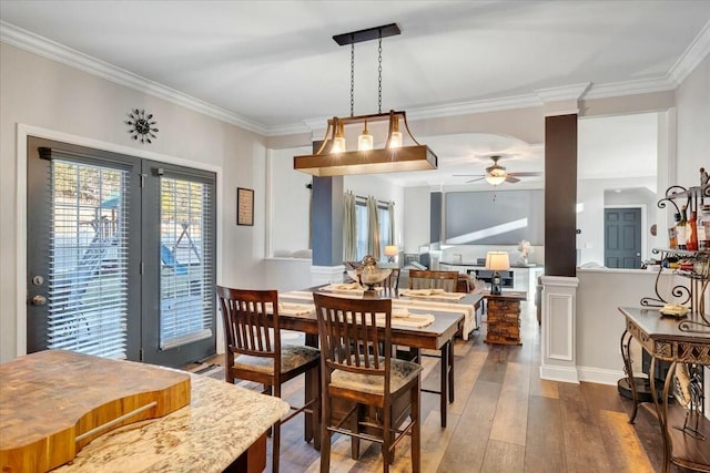 dining space with crown molding, dark wood-type flooring, and ceiling fan