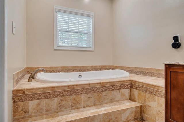 bathroom featuring vanity and tiled tub