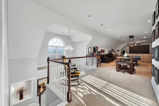 interior space with light colored carpet, lofted ceiling, and ceiling fan with notable chandelier