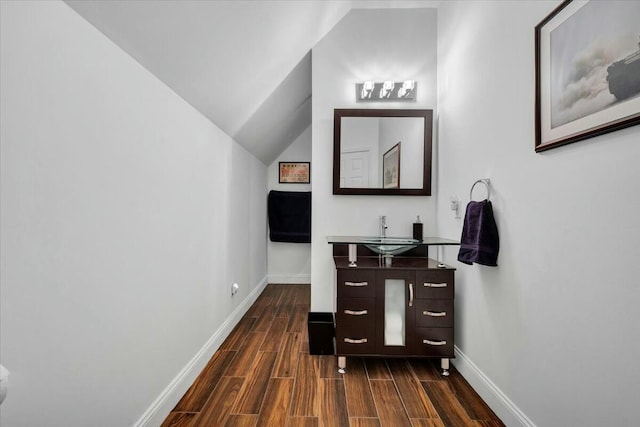 bathroom featuring vanity, vaulted ceiling, and hardwood / wood-style floors