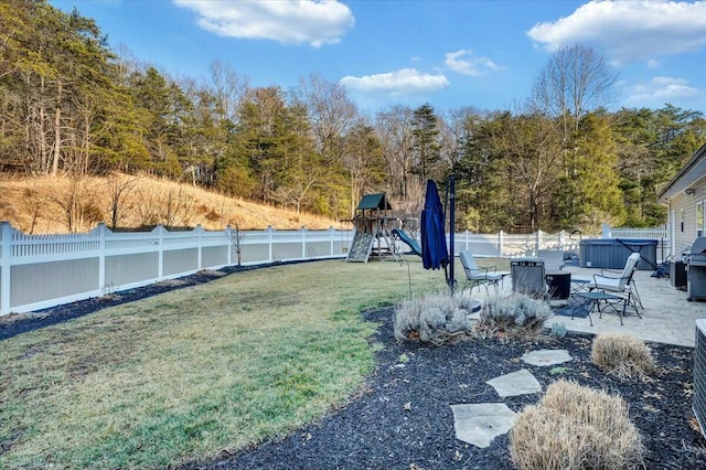 view of yard with a hot tub and a playground