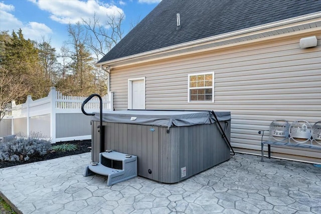 view of side of home with a hot tub and a patio