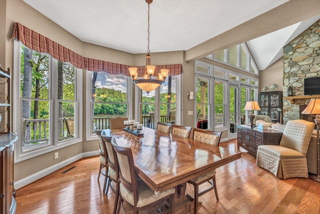 dining room with light wood-style flooring, a notable chandelier, and a healthy amount of sunlight