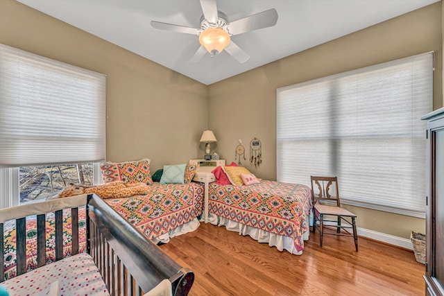 bedroom featuring baseboards, ceiling fan, and wood finished floors