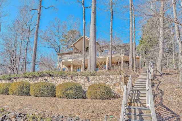 back of house featuring stairs and a balcony