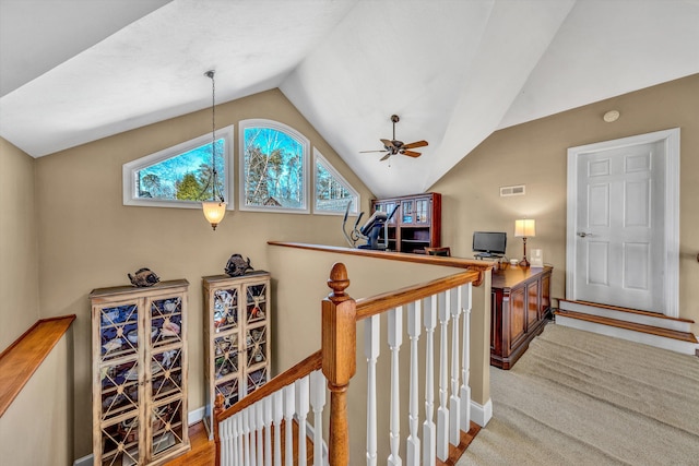 stairway featuring a healthy amount of sunlight, baseboards, visible vents, and lofted ceiling