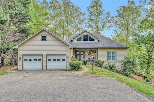 view of front of home with driveway, a shingled roof, and a garage