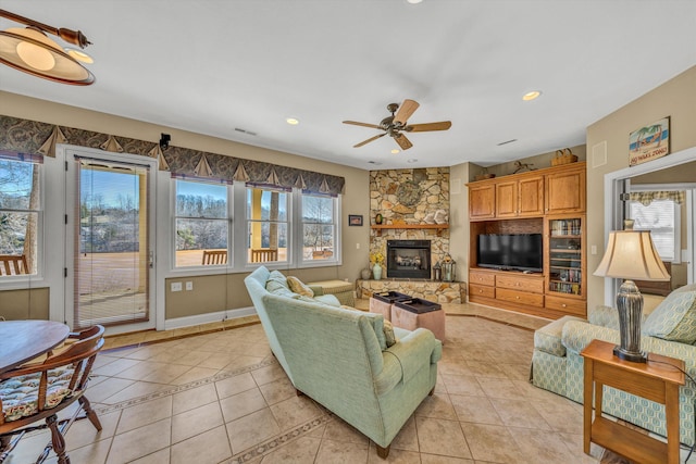 living room with ceiling fan, light tile patterned floors, a healthy amount of sunlight, and a fireplace
