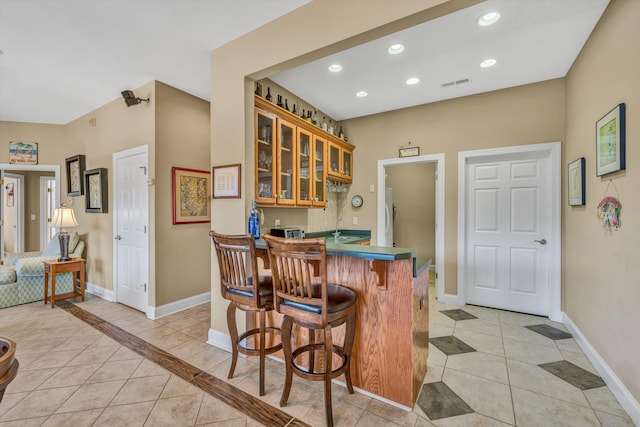 bar featuring light tile patterned floors, baseboards, recessed lighting, and wet bar