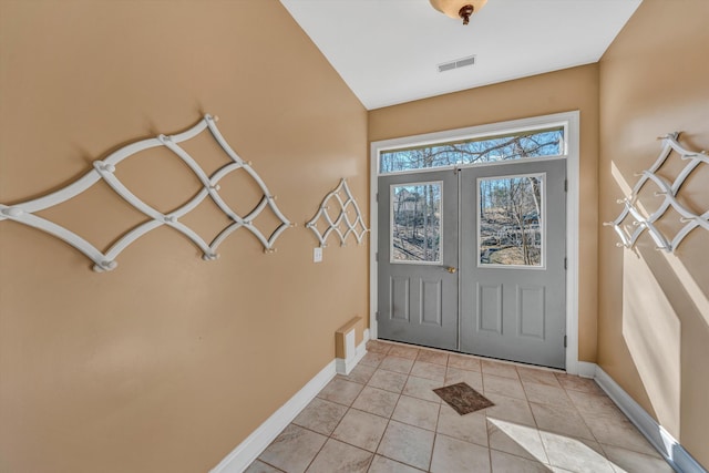 doorway to outside with visible vents, baseboards, light tile patterned floors, and french doors