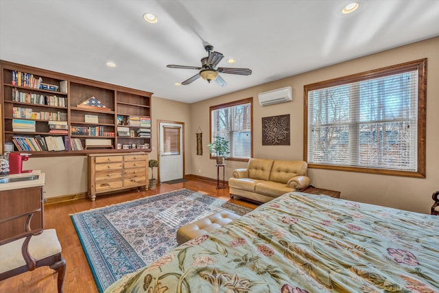 bedroom with baseboards, a wall mounted AC, recessed lighting, and wood finished floors